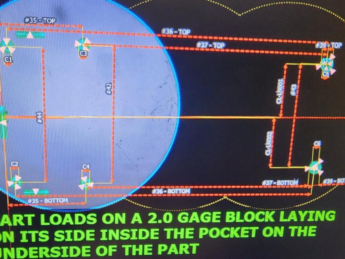 A digital CAD/Blueprint screen showing blue circles and yellow dimension lines with loading instructions in green text.