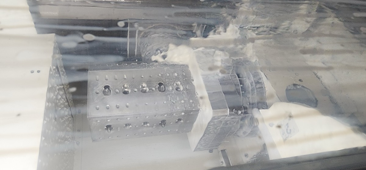 CNC machining in progress viewed through coolant window
